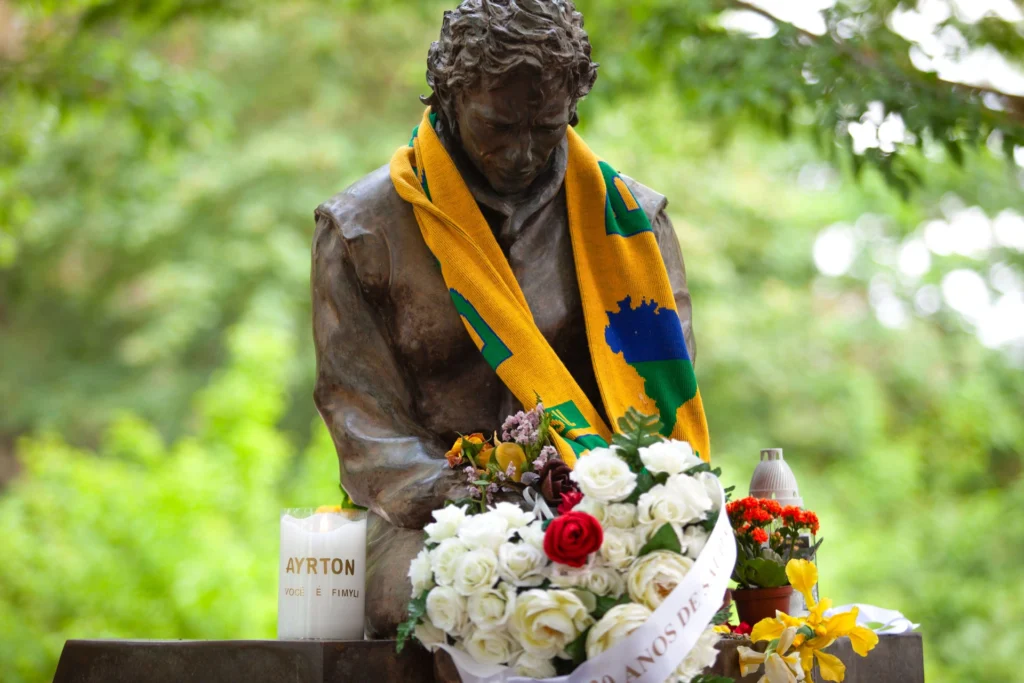 Busto de Ayrton Senna con ramo de rosas y vela de Fimyli - vista frontal de la ceremonia conmemorativa
