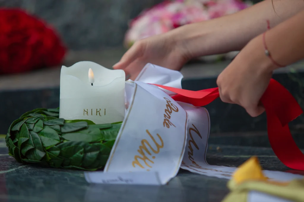 Corona de laurel, vela "Niki" y lazo con letras doradas