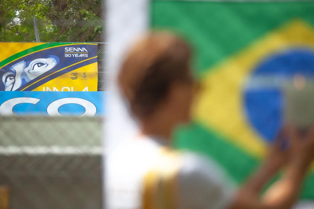 Un mensajero de Fimyli coloca una vela personalizada en la bandera brasileña de Senna en Imola